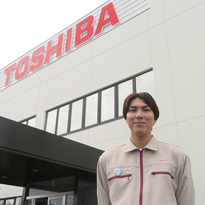 豊前東芝エレクトロニクス 本社 正面玄関に立つオプトデバイス製造部　半導体製造工程リーダー　T.Aさん